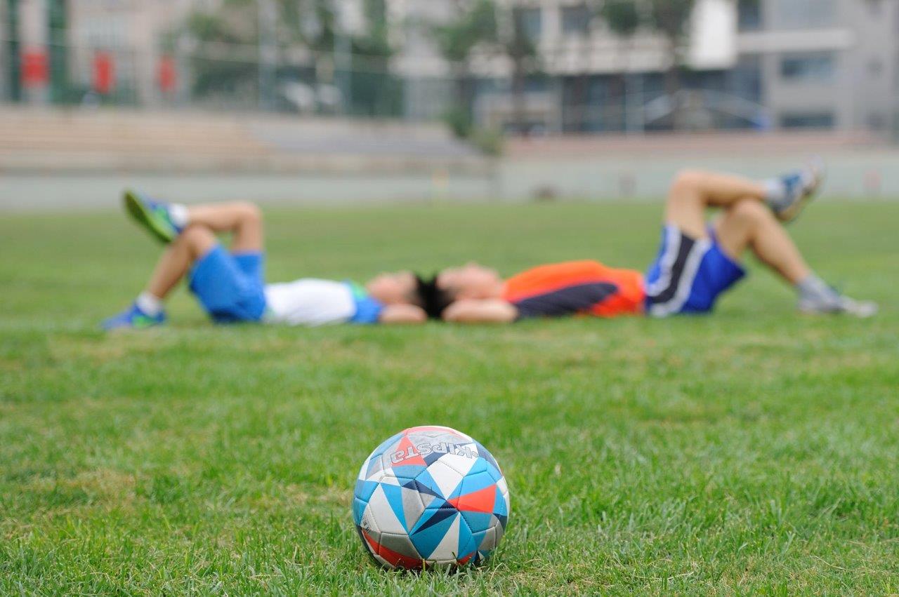 kids laying down in a soccer field