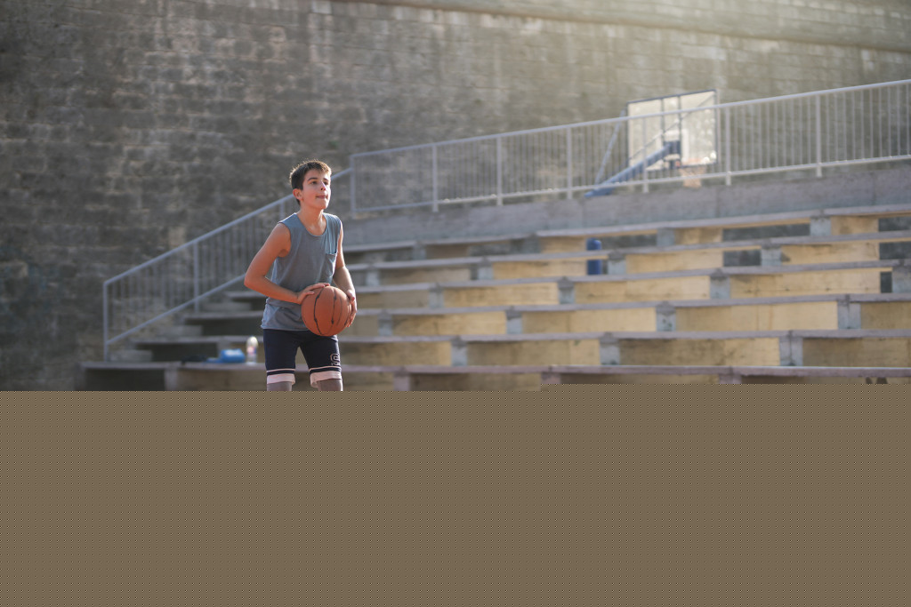 teenage boy training in basketball court
