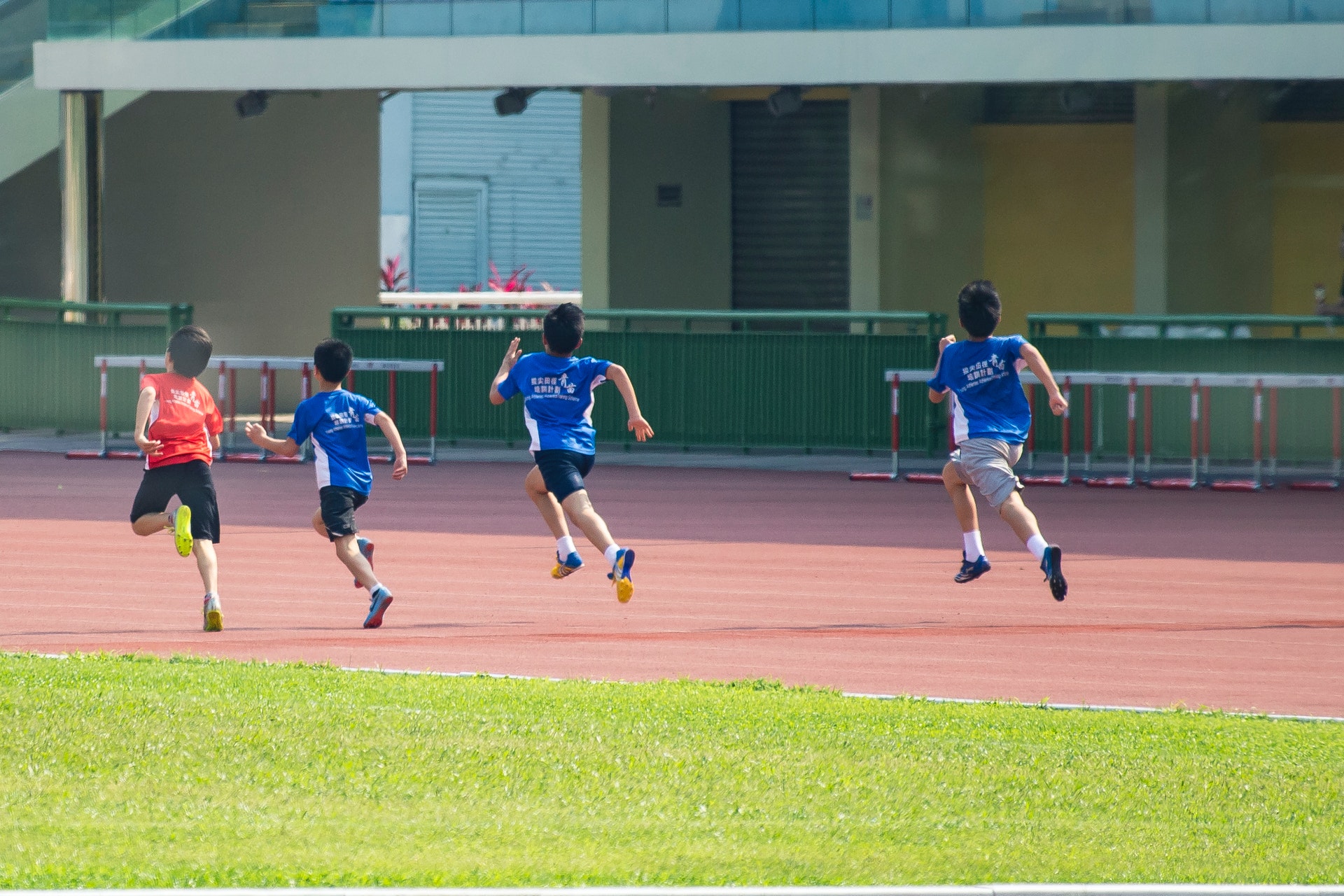 four boys running in track