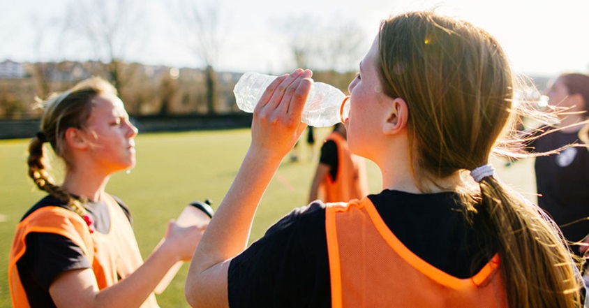 Girl drinking water on sidelines