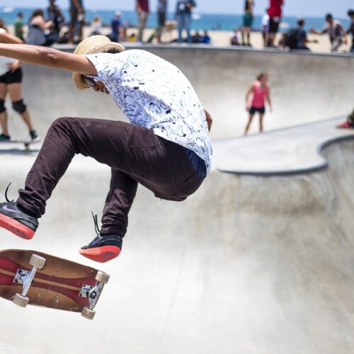 Young skateboarder performing stunt in skate park