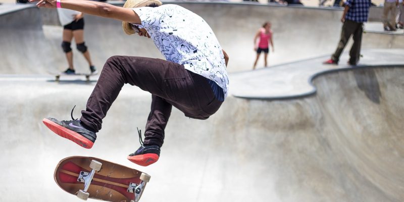 Young skateboarder performing stunt in skate park