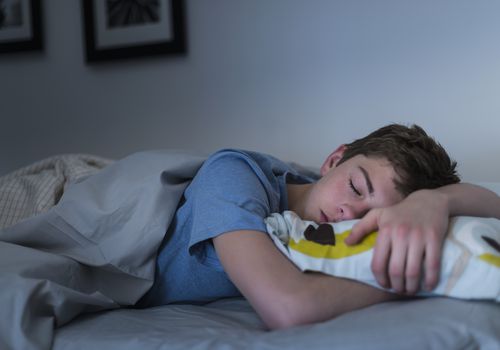 Teenager sleeping in bed at night