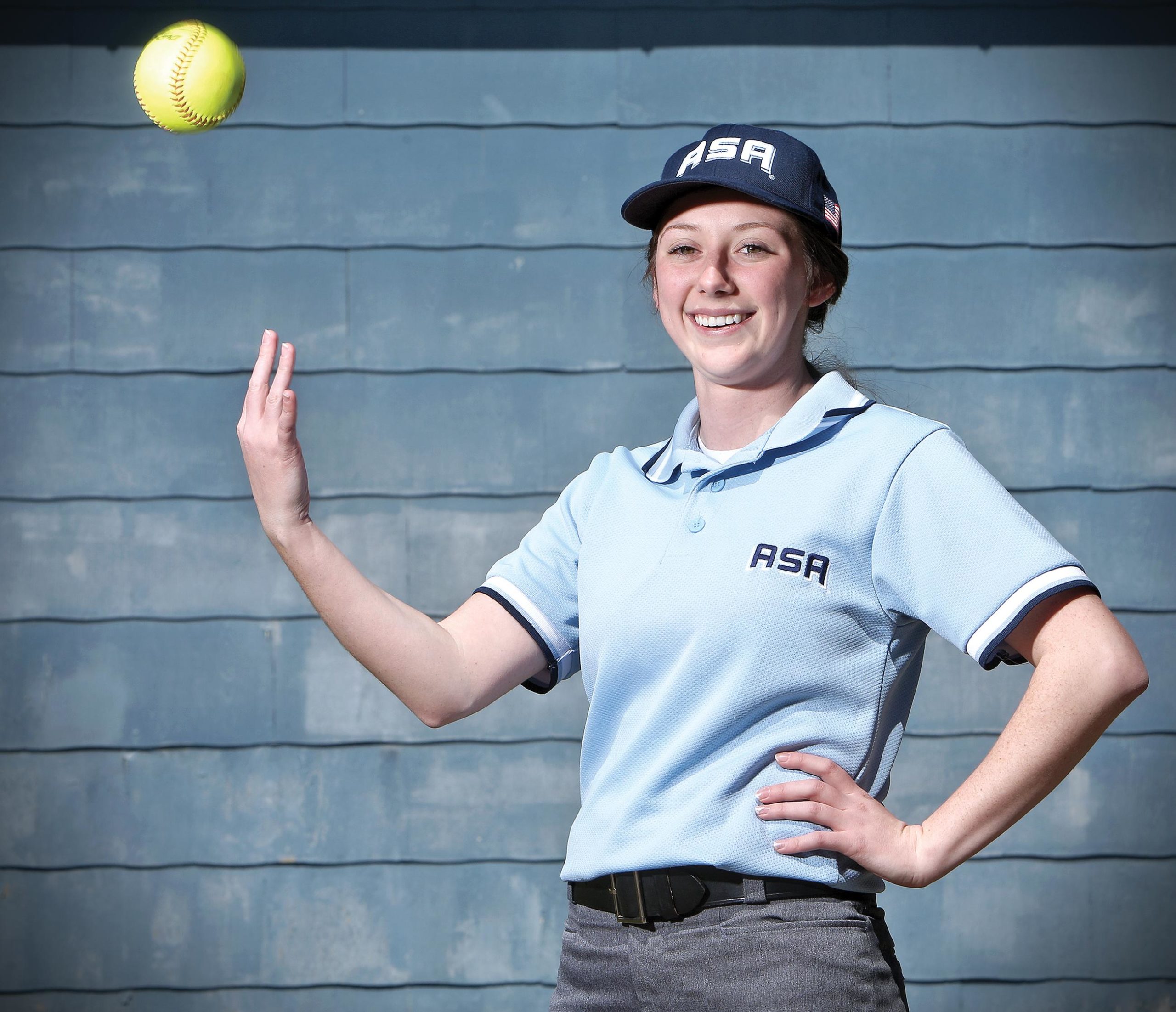Teenage umpire tossing baseball to self with one hand