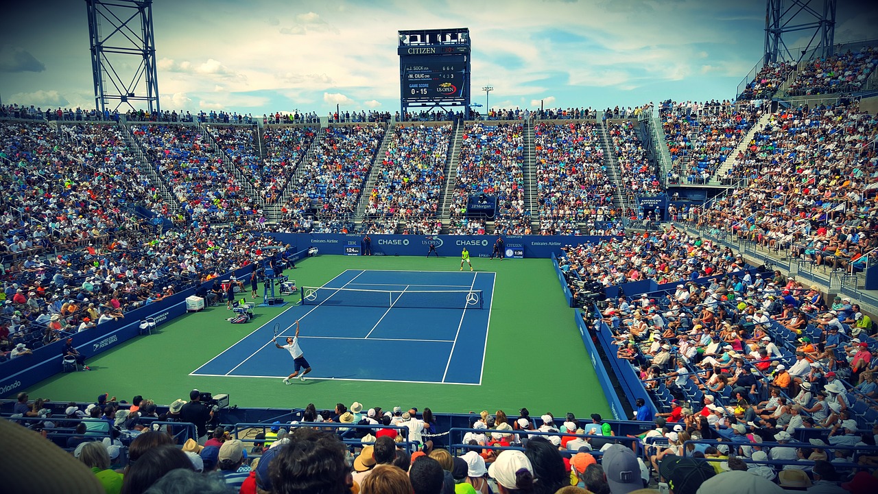 Full tennis stadium with two players in singles match on court