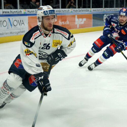 Hockey players on rink with sticks and gear