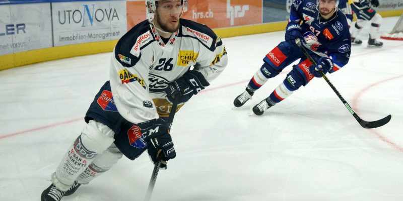 Hockey players on rink with sticks and gear