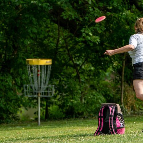 Parent playing disc golf in field