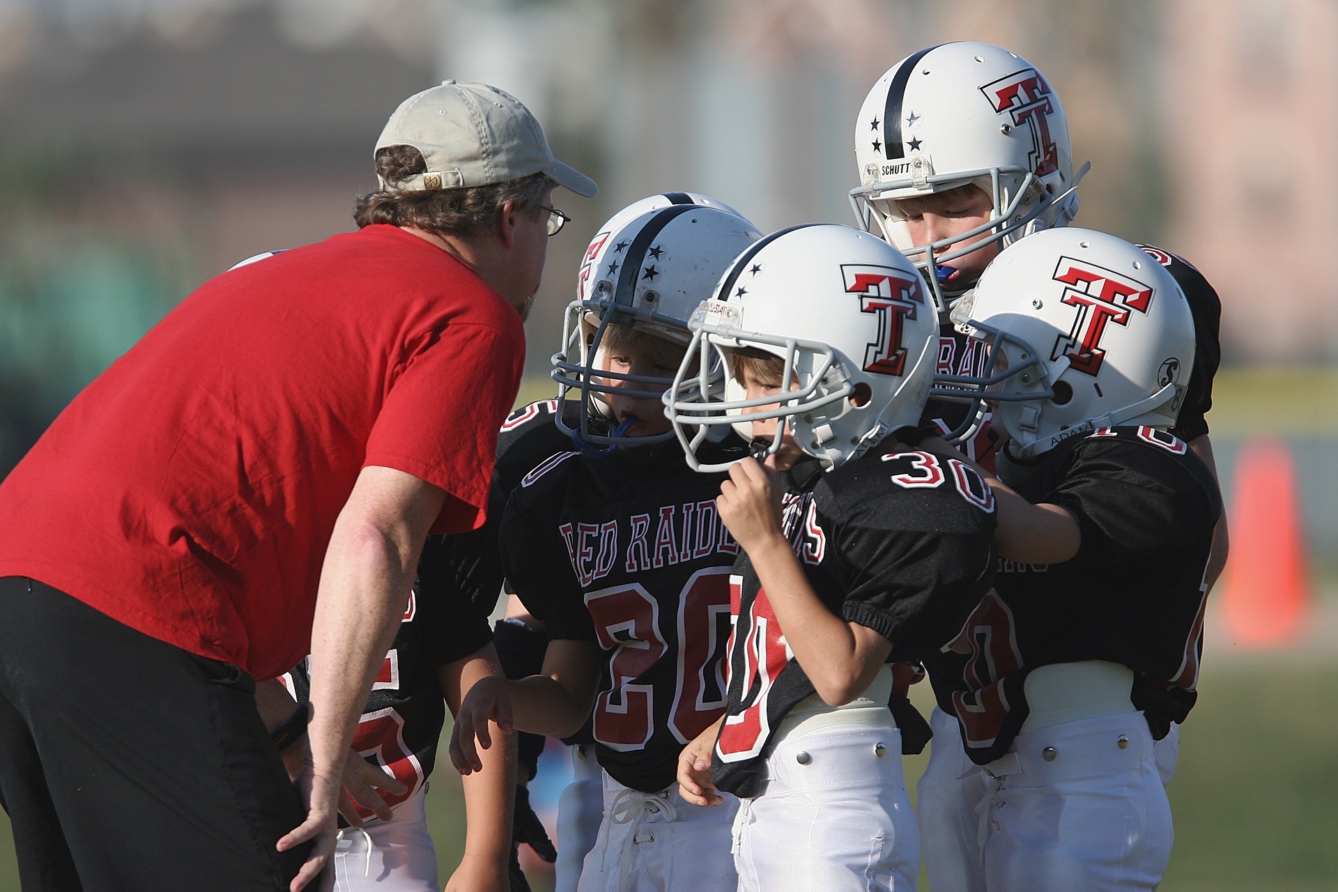 Young football players gathered in huddle during game