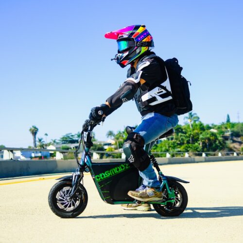 Child with colorful helmet on PEV scooter