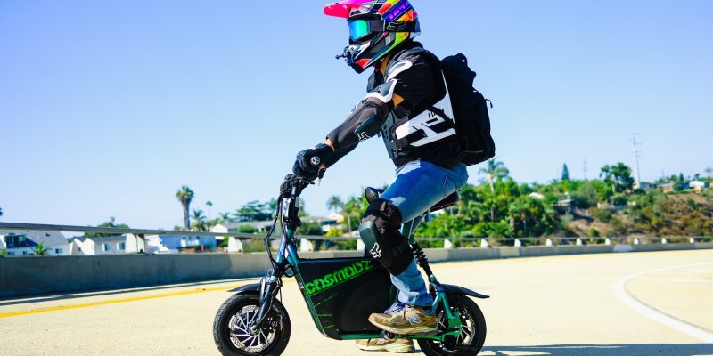 Child with colorful helmet on PEV scooter