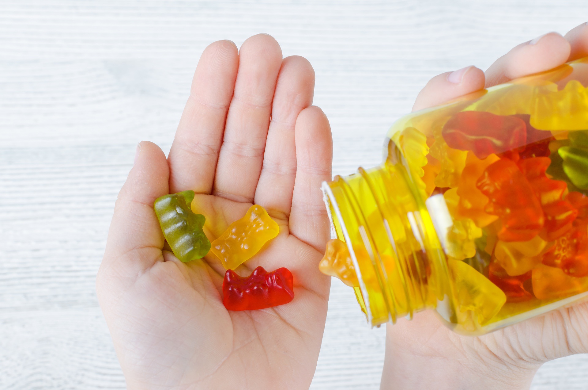 Gummy vitamins being dumped into a hand