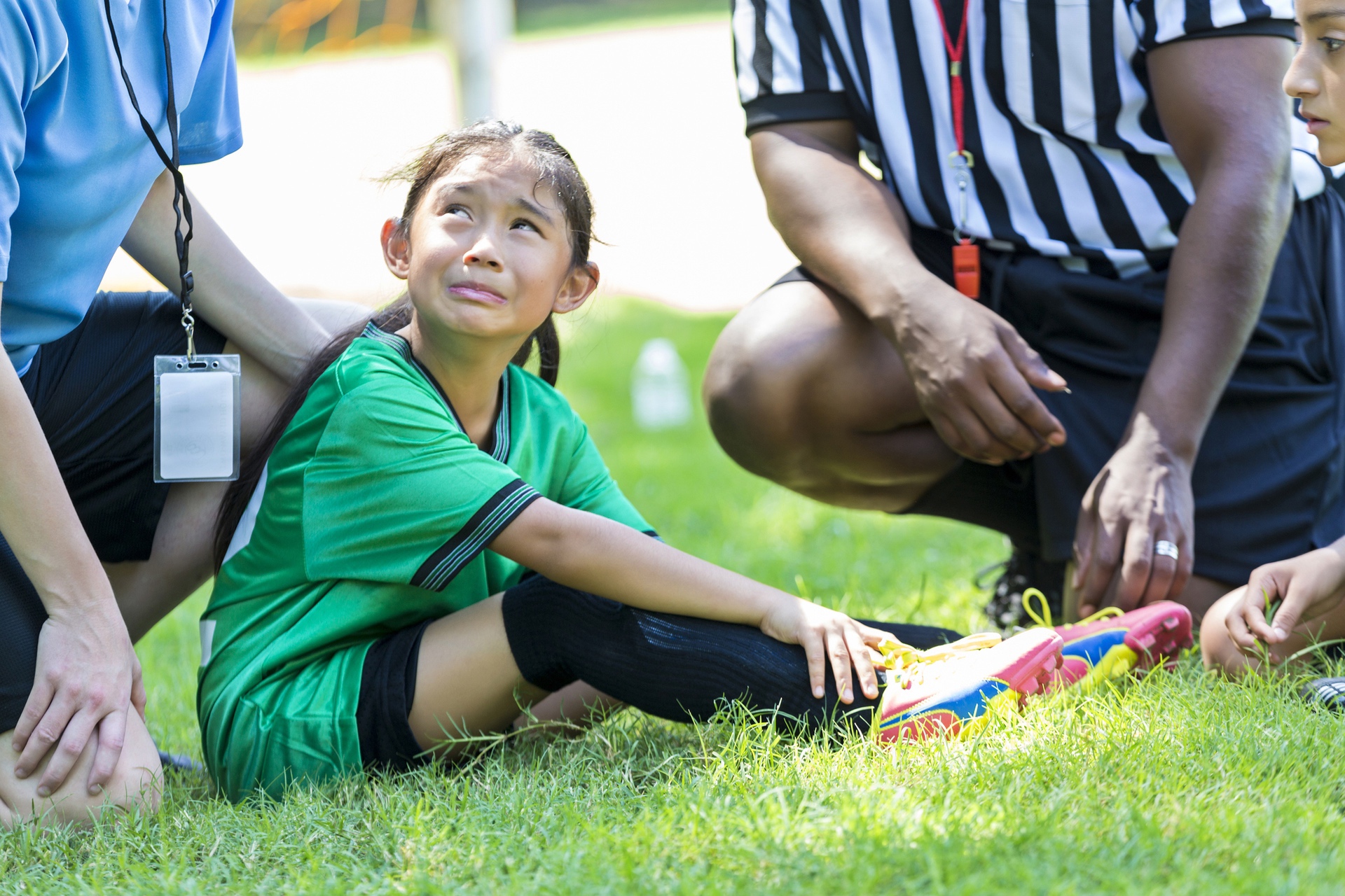 Young athlete holding shin after suffering from shin splints during game